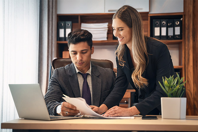 Man and woman in office looking at paperwork