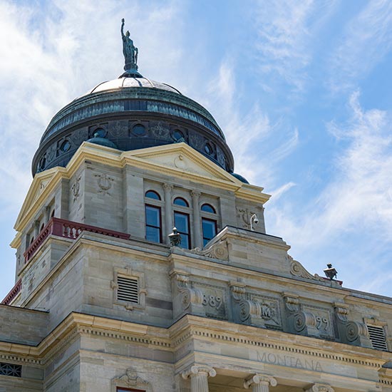 Montana Capital building looking up from the front of the building toward the dome and statue at the top.